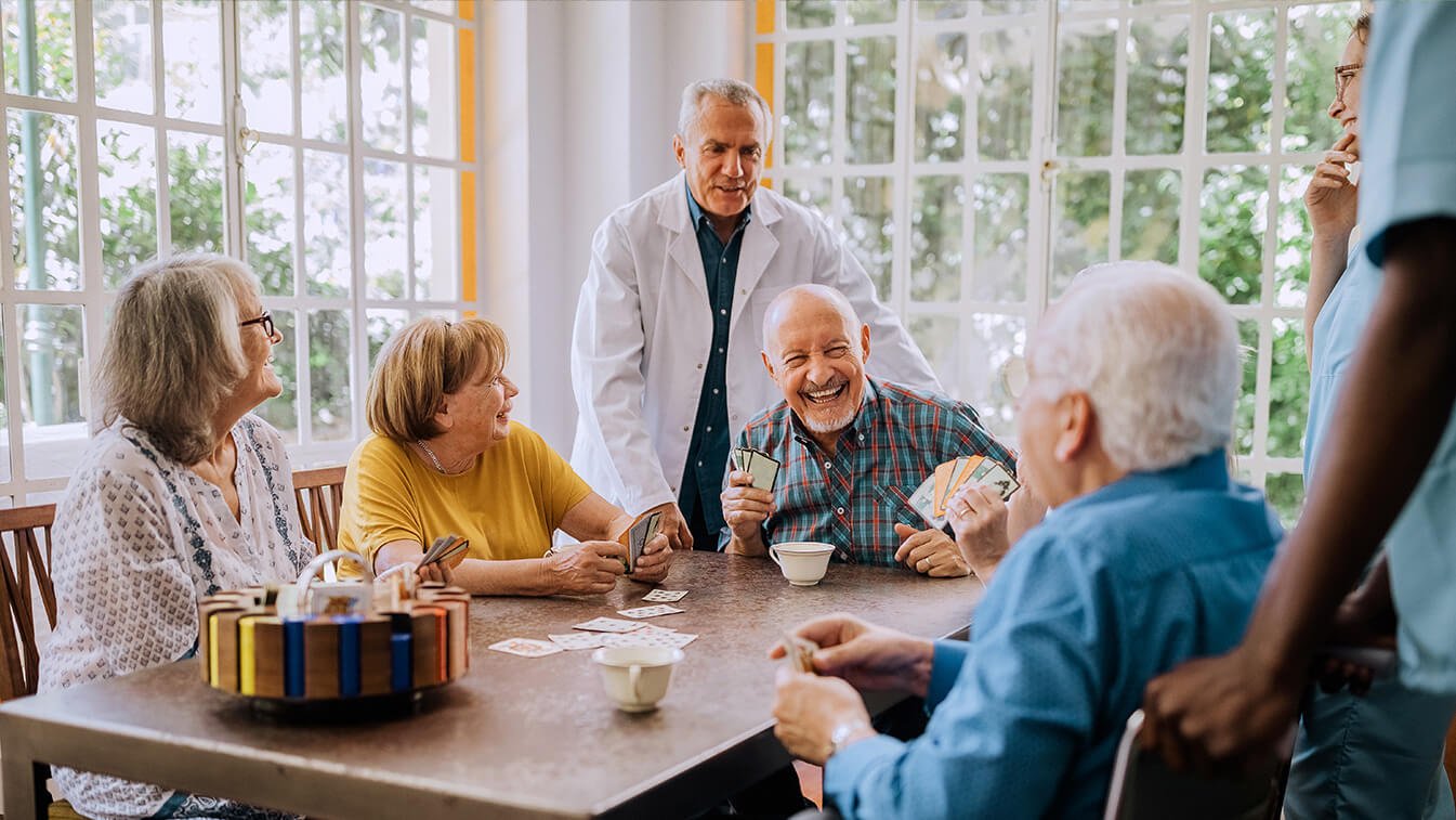 Seniors enjoying playing cards with doctor